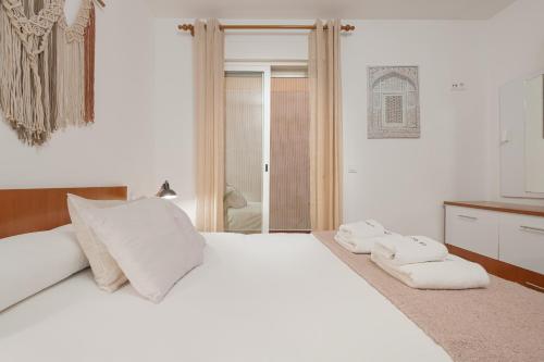马拉加C55 Cosy Apartment close to the beach的卧室配有白色的床和2条毛巾