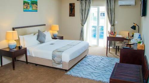 HarbelTIME Royal Ambassador Hotel的卧室配有一张白色大床和一张书桌