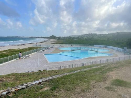 Saint MartinStudio Tamarin的两个游泳池位于海边的海滩上