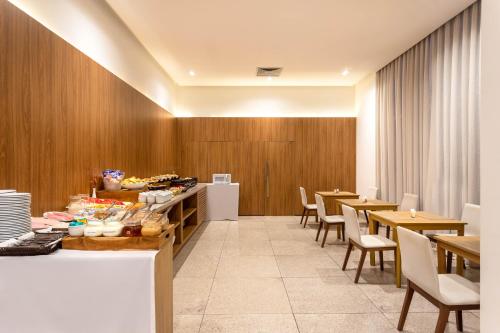 巴西利亚Ramada by Wyndham Brasilia Alvorada的餐厅拥有木墙和桌椅
