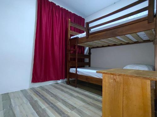 拉克鲁斯Papaturro House的一间卧室设有两张双层床和红色窗帘