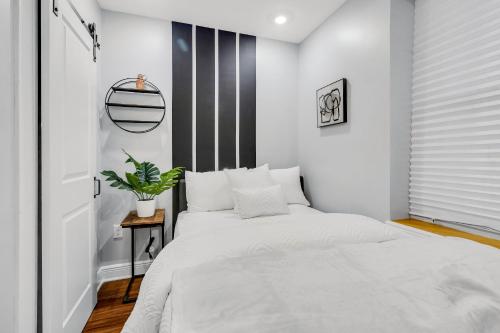 费城Fairmount Art Museum Center City Suites的卧室配有白色的床和黑白墙