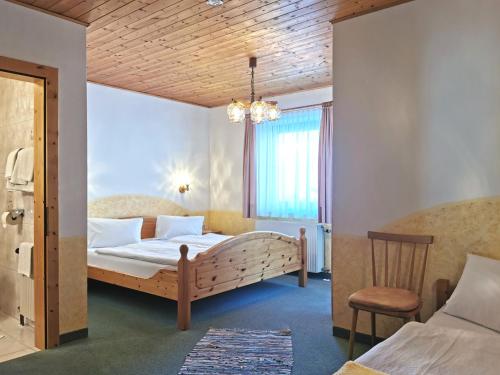 海利根布卢特克里斯托弗乡间别墅酒店的一间卧室配有一张大床和一把椅子