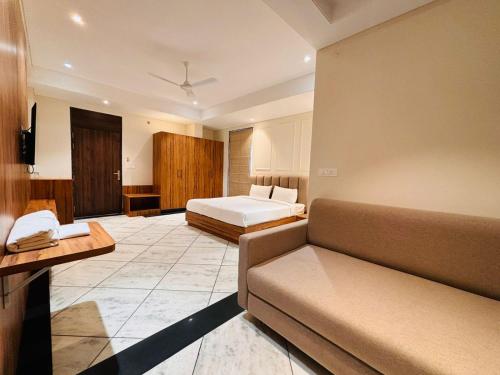 斋浦尔Hotel Saaj Mansion的酒店客房,配有床和沙发
