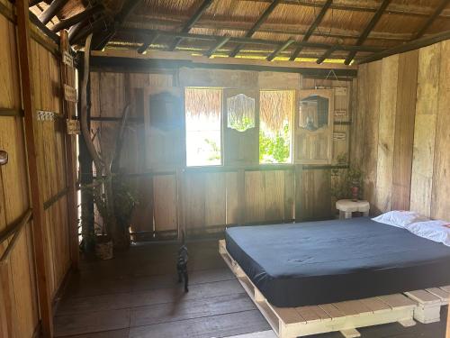 Playa Punta ArenaPunta Arena EcoHostal & EcoFit - Your Eco-Friendly Oasis 02的木制客房内的一间卧室,配有一张床