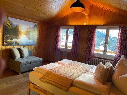 格林德尔瓦尔德Jägerstübli Grindelwald的一间卧室配有一张床、一张沙发和窗户。