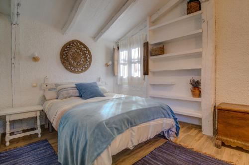 厄尔巴拉克La cabaña del Burguillo的卧室配有床架,位于带书架的房间