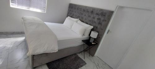 鲸湾港Walvis Bay Staycation的小卧室配有带白色床单和枕头的床