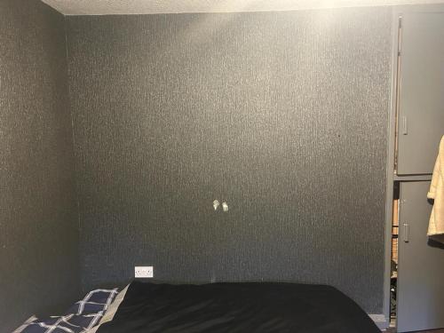 海伍德Heywood的卧室配有灰色墙壁和床