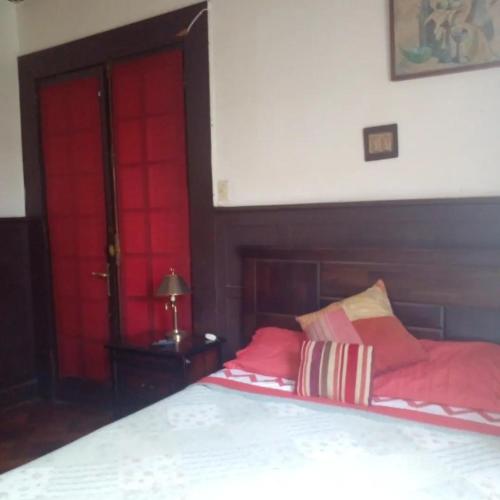 维纳德马Hostal María Luisa Bombal的卧室设有红色门,配有红色枕头