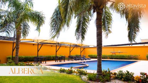 雷诺萨Altavista Hotel的一个带游泳池和棕榈树的度假村