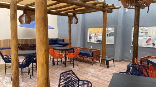 圣弗朗西斯科-迪伊塔巴波阿纳Pousada Casa da Praia SFI的餐厅设有椅子、桌子和桌椅