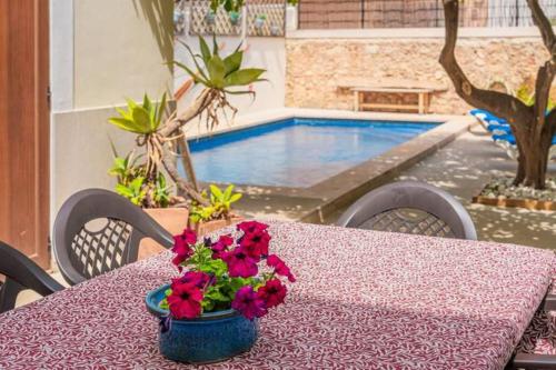 比尼萨勒姆Sa Llimonera de Binissalem, piscina privada ideal familias, 6 dormitorios con aire acondicionado的桌子上带花瓶的桌子和游泳池