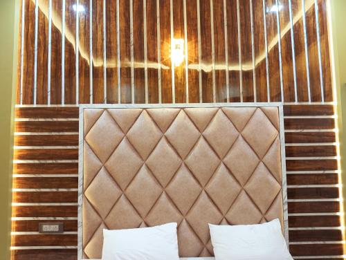 BhabuaHotel Ashok Vihar的一张棕色床头板上方灯床