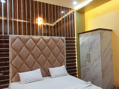 BhabuaHotel Ashok Vihar的一间卧室配有一张带软垫床头板的床