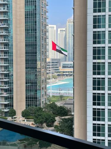 迪拜Stylish New 2BR l Spacious with Burj & Fountain Views l near Dubai Mall l Pool l Gym的红旗在高楼前飘扬