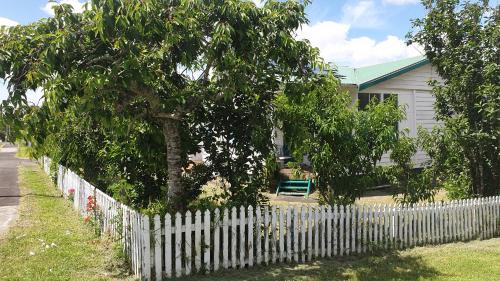 奥克兰Green Getaway- Unique, 4 bedroom Bungalow Papakura的树屋前的白色围栏