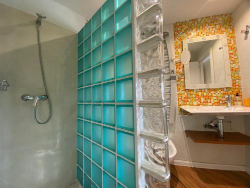 圣胡安·德·阿利坎特Encantador Ático a 2,6 km de la Playa的浴室设有蓝色瓷砖墙壁和淋浴。