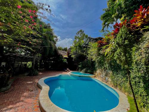 埃尔扎伊诺Lodge Cacao的鲜花庭院中的游泳池