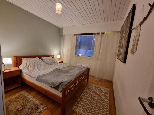 波里Päätyhuoneisto: Nariseva puulattia!的一间卧室设有一张床和一个窗口