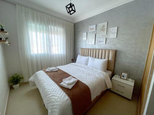 穆罕默迪耶Appartement avec piscine - Mohammadia的一间卧室设有一张大床和一个窗户。