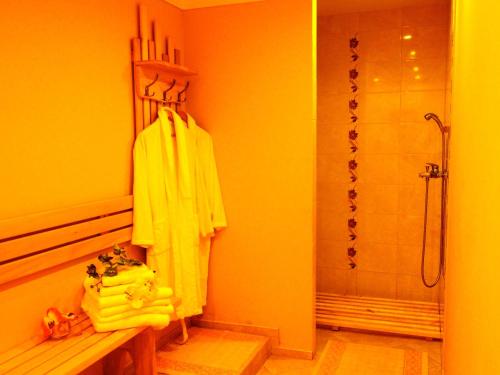 约尼什基斯赛瑞威泰酒店的带淋浴和黄色浴袍的浴室