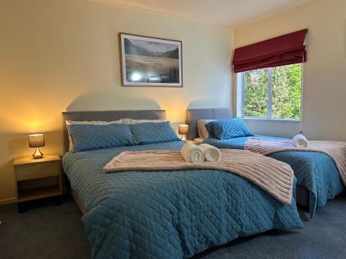 奥克兰New Lynn Self- Contained Unit near Golf Course的一间卧室设有两张床和窗户。