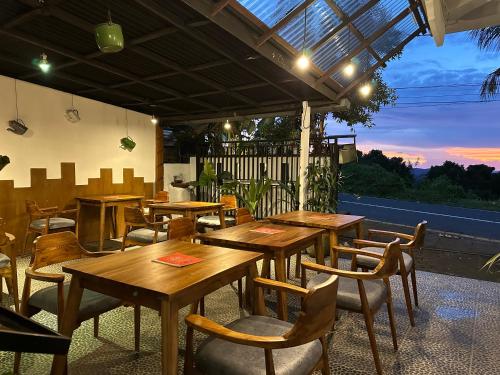 姆杜克Dong Paloh Hostel的庭院中设有木桌椅的餐厅
