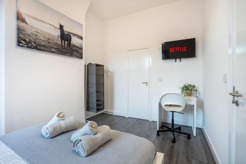 巴罗弗内斯`isimi Luxurious 4 bed 4 ensuite house的一间卧室配有一张床、一张书桌和一台电视。