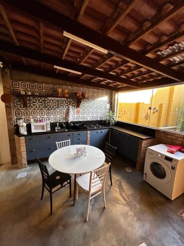 阿雷亚Casarão 47的厨房配有桌椅、洗衣机和烘干机