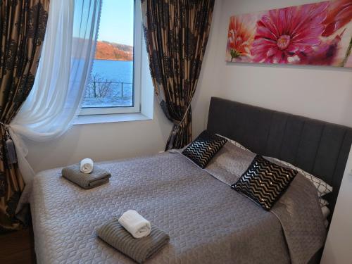 卑尔根Bergen sunrise Apartment - self check in - Free Parking的一间卧室配有带毛巾的床和窗户。