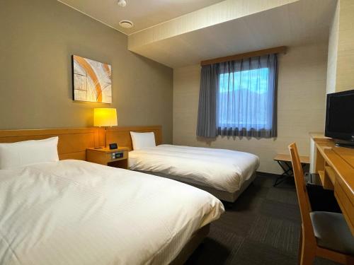 天童市天童旅馆酒店的酒店客房设有两张床和电视。