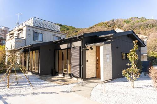 箱根Stagione Hakone Yumoto Villa スタジオーネ箱根湯本VILLA的黑色和白色外墙的房子