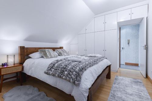 伊灵Cosy Flat In London的白色卧室配有一张大床和一张桌子