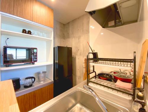 Mongawaさくらや旅館的一间带水槽和冰箱的小厨房