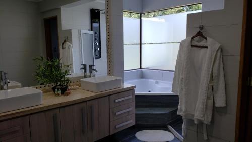 普孔Borde Luz Hotel Boutique的带浴缸、两个盥洗盆和浴缸的浴室。