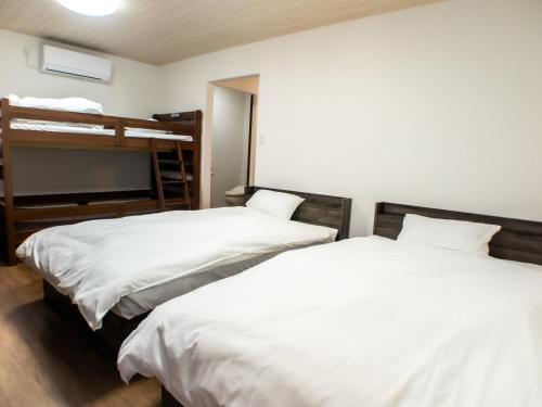 佐渡市Shima no Hotel的带两张双层床的客房中的两张床