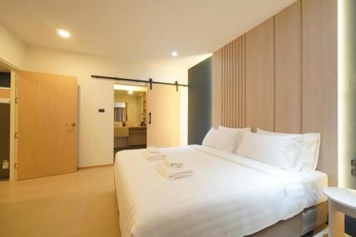 美索Alto Hotel M的卧室配有带毛巾的大型白色床