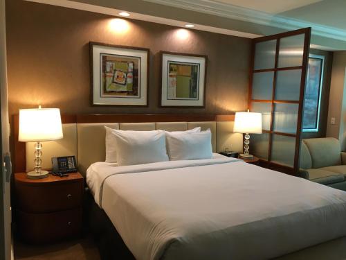 拉斯维加斯MGM Signature Condo Hotel by Owner - No Resort Fee !!的一间卧室配有一张带两盏灯和一把椅子的床。