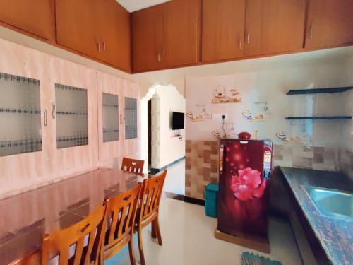 哥印拜陀luxury home in Vadavalli的厨房配有桌椅和冰箱。
