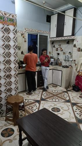 贾纳克布尔Mithila Culture Janakpurdham Homestay的站在厨房里的两个人