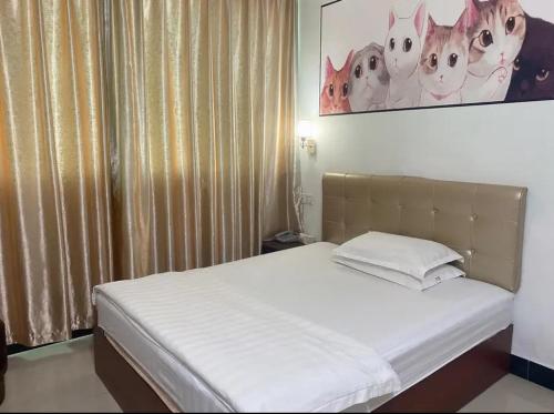 Plei KhưnKhách sạn Hữu Nghị 674的卧室内的一张床位,上面有猫的照片
