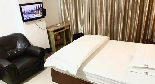 Plei KhưnKhách sạn Hữu Nghị 674的一间卧室配有一张床、一把椅子和电视