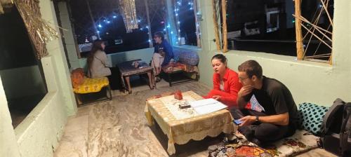 布什格尔Hotel Poonam Pushkar的两个人坐在一个房间里桌子上
