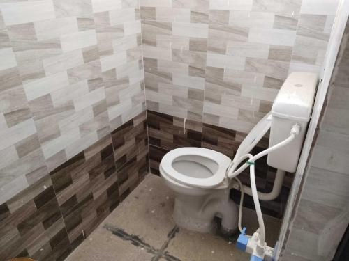 尼玛纳OYO Neelkanth Hotel & OYO Rooms的浴室位于隔间内,设有白色卫生间。