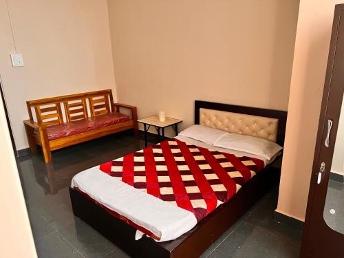 因帕尔OYO Decent Inn的一间卧室配有一张带红白毯子的床