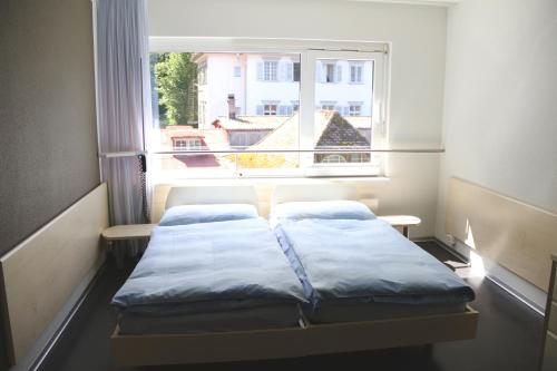 卢塞恩裡什蒙酒店的一间小房间,窗户前设有两张床