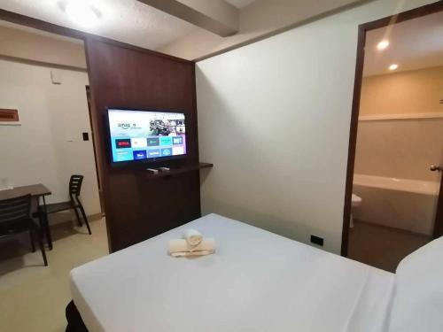 CaintaSunny Day Residences Cainta的一间设有床铺和电视的房间