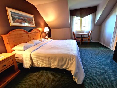 圣索弗尔-德斯蒙特Hotel Alila的卧室配有一张白色的大床和一张桌子