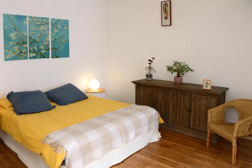 欧特维尔－隆普内斯Le pied-à-terre du botaniste的一间卧室配有带2个枕头和椅子的床